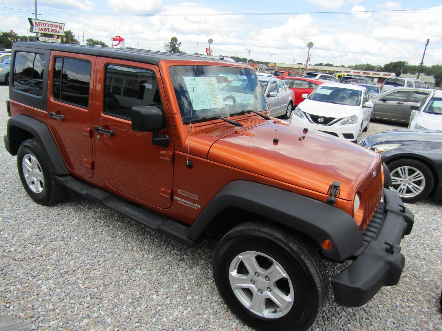 2011 Orange /Black Jeep Wrangler Unlimited Sport 4WD (1J4BA3H16BL) with an 3.8L V6 OHV 12V engine, Automatic transmission, located at 15016 S Hwy 231, Midland City, AL, 36350, (334) 983-3001, 31.306210, -85.495277 - Photo#0